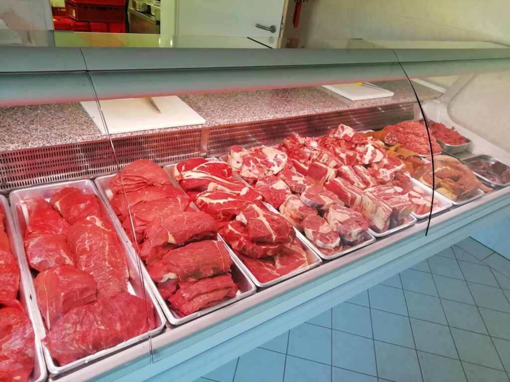 Eine Metzgereitheke voller rohem, rotem Fleisch verschiedener Schnitte und Größen